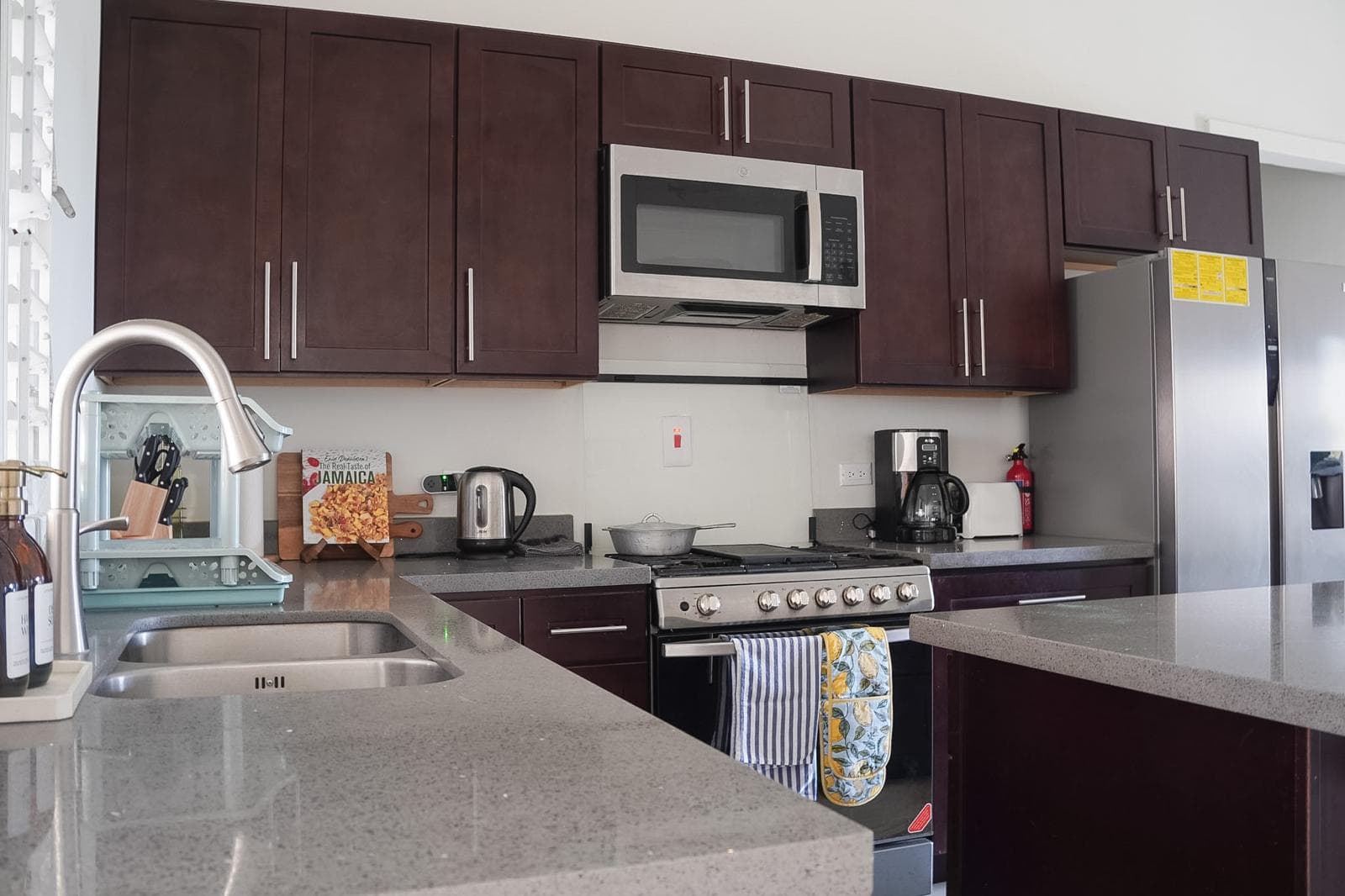 A bright and clean view of the holiday home kitchen highlights everything needed to prepare fresh Jamaican coffee and delicious home-cooked dinners.